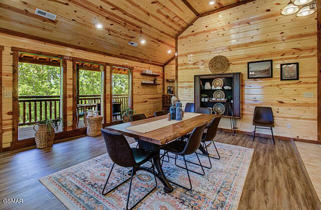 dining space with wood walls, dark wood-type flooring, and wood ceiling