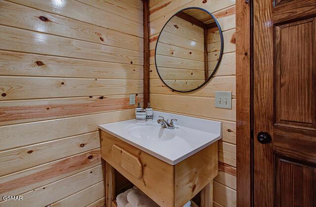 bathroom featuring vanity and wood walls