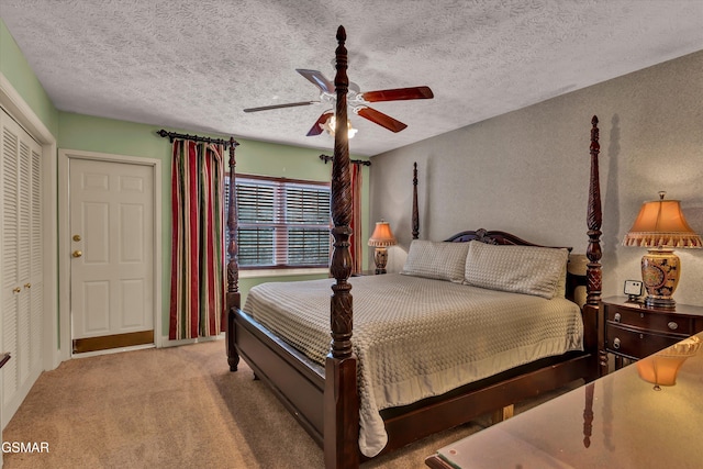 carpeted bedroom featuring ceiling fan, a textured ceiling, and a closet