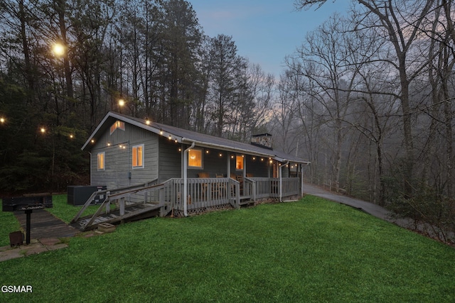 view of front of home with central AC and a lawn