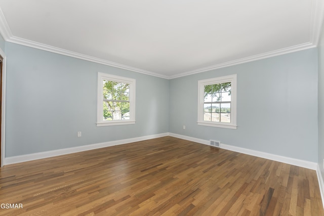 spare room featuring hardwood / wood-style flooring and ornamental molding