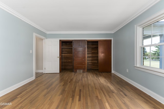 unfurnished bedroom with crown molding, a closet, and dark wood-type flooring