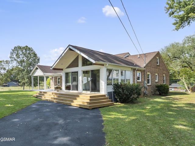 rear view of house featuring a yard