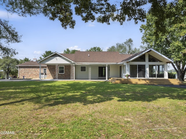 ranch-style home featuring a wooden deck and a front lawn