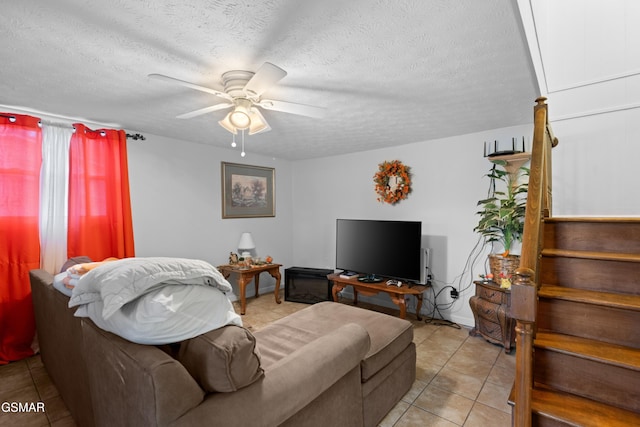 tiled living room featuring ceiling fan and a textured ceiling