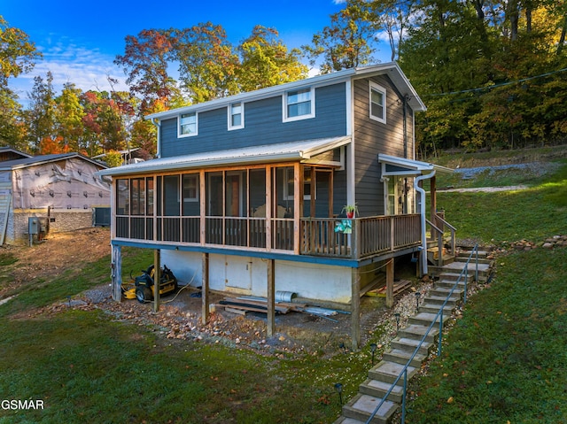 back of property featuring a sunroom and a yard