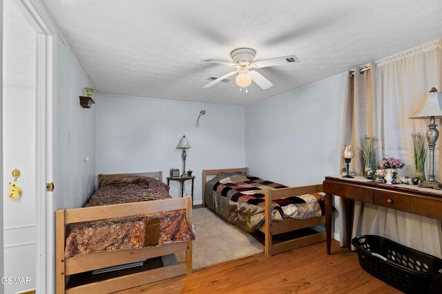 bedroom featuring a textured ceiling, light hardwood / wood-style floors, and ceiling fan