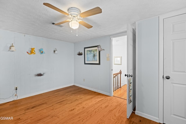 unfurnished room featuring a textured ceiling, light hardwood / wood-style flooring, and ceiling fan