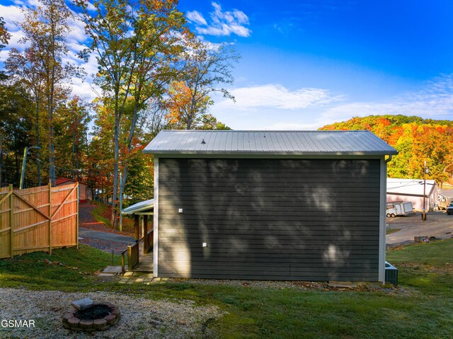 view of outbuilding featuring a lawn and cooling unit