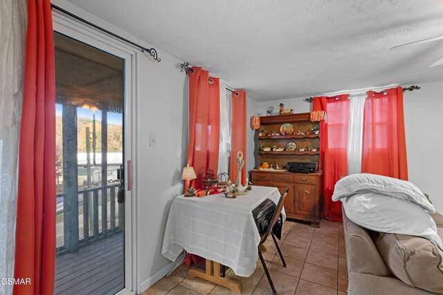 dining room with a textured ceiling, ceiling fan, and light tile patterned flooring