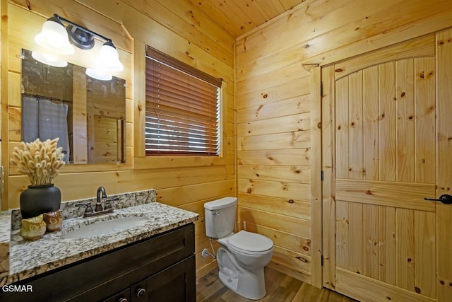 bathroom featuring vanity, wooden walls, hardwood / wood-style flooring, toilet, and wood ceiling