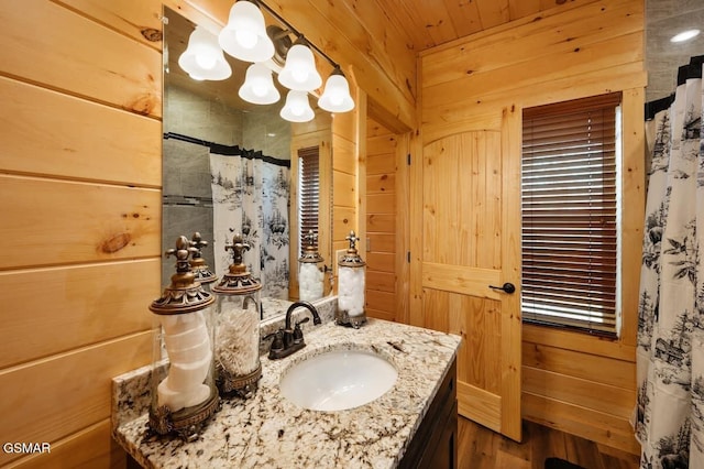 bathroom featuring vanity and wood walls