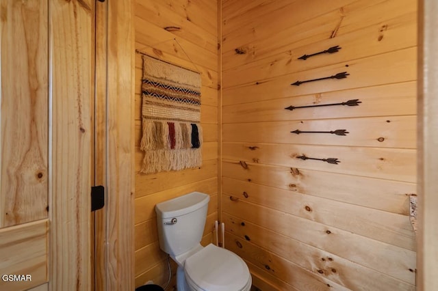 bathroom with toilet and wood walls