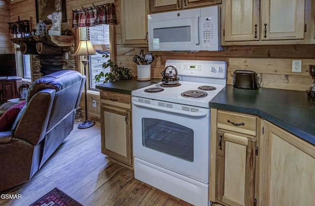 3050 Headrick Dr, Sevierville, TN 37862 - kitchen with wood finished floors, light brown cabinetry, dark countertops, white appliances, and a stone fireplace