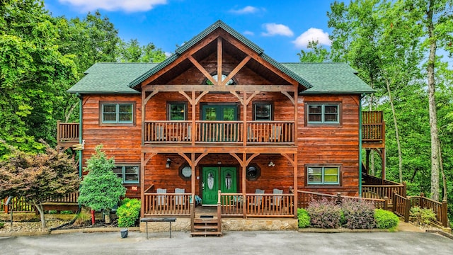 log home featuring a porch and a balcony