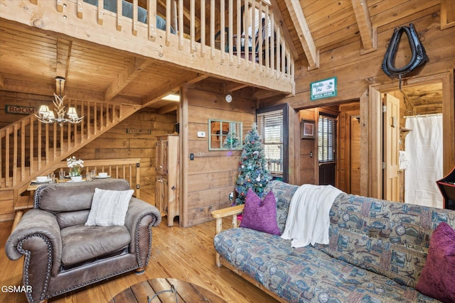 living room with wooden walls, wooden ceiling, an inviting chandelier, and hardwood / wood-style floors