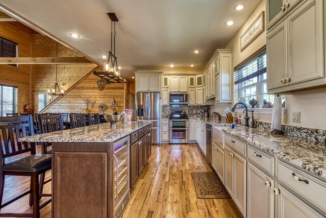 810 Oakley Way, Gatlinburg, TN 37738 - kitchen with appliances with stainless steel finishes, a kitchen breakfast bar, light wood-type flooring, decorative light fixtures, and a kitchen island