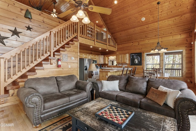 2851 Indigo Ln, Sevierville, TN 37862 - living room with stairway, ceiling fan with notable chandelier, light wood finished floors, and high vaulted ceiling