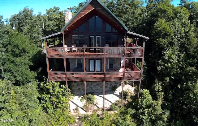 2851 Indigo Ln, Sevierville, TN 37862 - back of property featuring a chimney, stone siding, a view of trees, and a deck