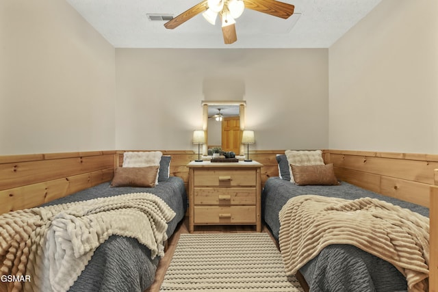 2851 Indigo Ln, Sevierville, TN 37862 - bedroom with wood walls, wood finished floors, visible vents, a ceiling fan, and wainscoting
