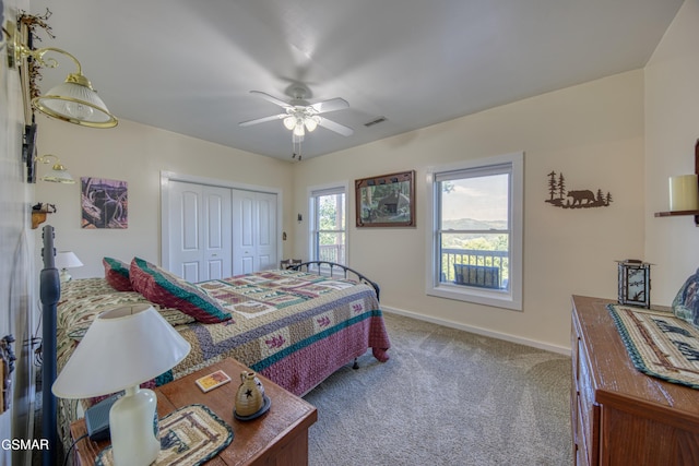 carpeted bedroom with a ceiling fan, baseboards, visible vents, and a closet