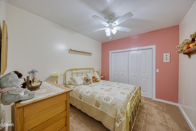 bedroom with a closet, light carpet, ceiling fan, and baseboards