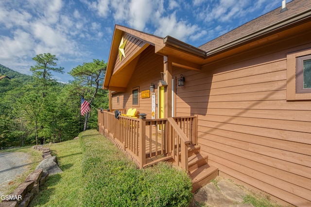 entrance to property featuring a deck and a yard