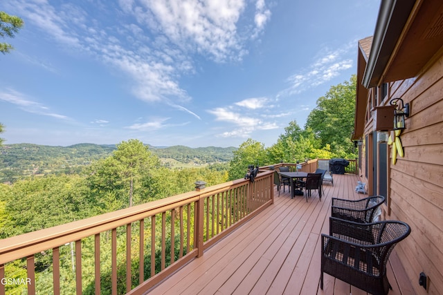 wooden deck featuring outdoor dining area and a mountain view