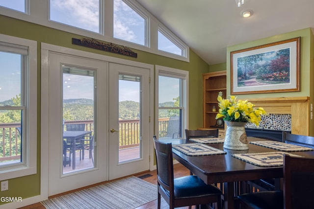 dining space with light wood-type flooring, lofted ceiling, french doors, and visible vents