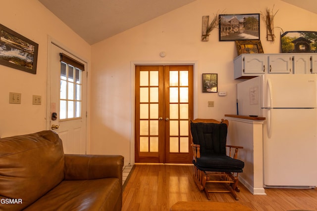 interior space featuring french doors, lofted ceiling, and light wood-type flooring