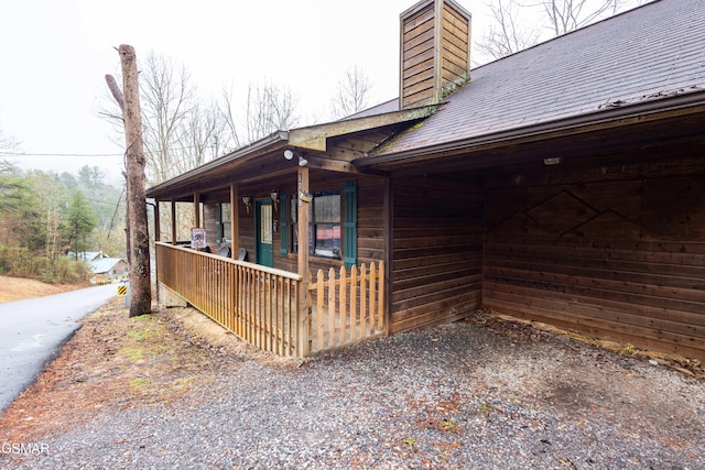 view of side of home featuring covered porch