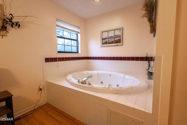 bathroom featuring hardwood / wood-style floors and tiled bath