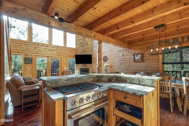 kitchen featuring stone counters, beam ceiling, high end stove, and wood walls