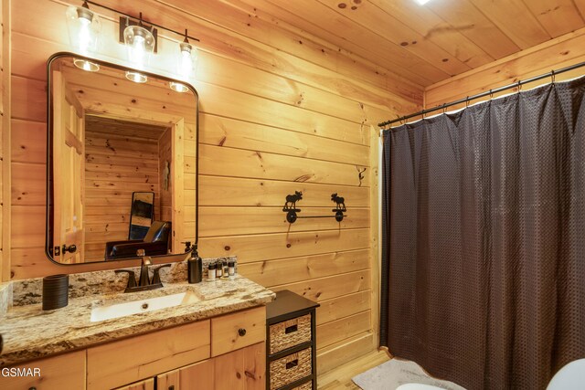 bathroom with curtained shower, wooden walls, sink, and wooden ceiling