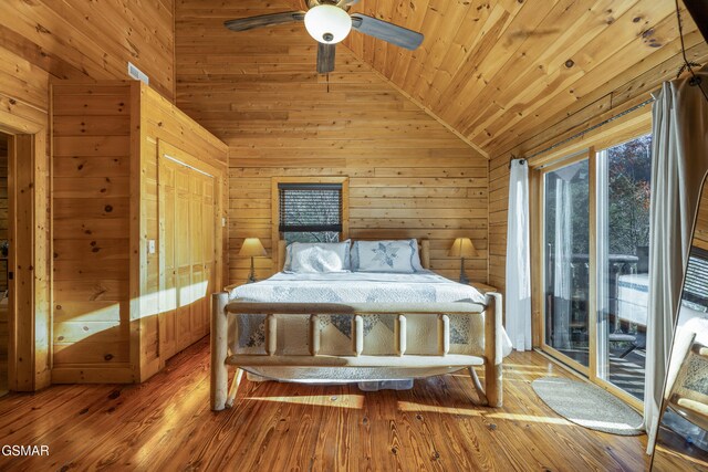 unfurnished bedroom featuring vaulted ceiling, ceiling fan, hardwood / wood-style flooring, wooden ceiling, and wood walls