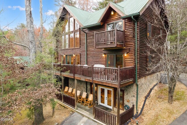 rear view of house with a balcony and french doors