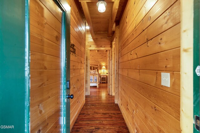 corridor featuring beam ceiling, dark hardwood / wood-style flooring, wooden ceiling, and wooden walls