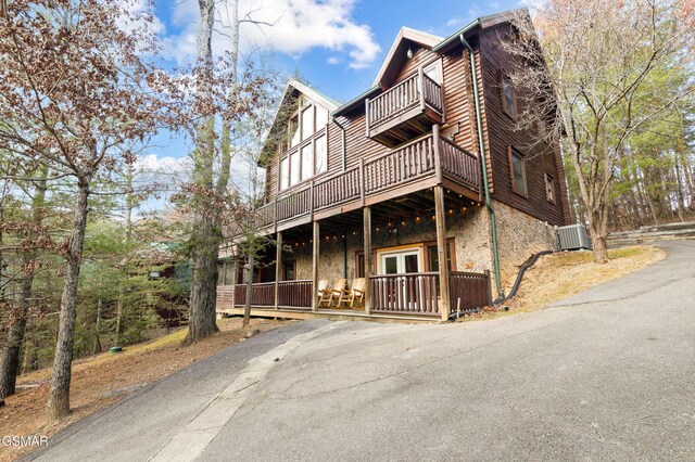 view of front of house with central AC, french doors, and a balcony