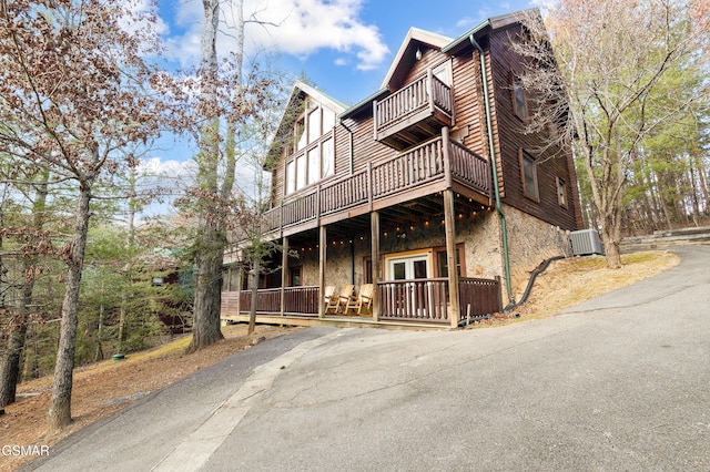 view of front of house with central AC, french doors, and a balcony