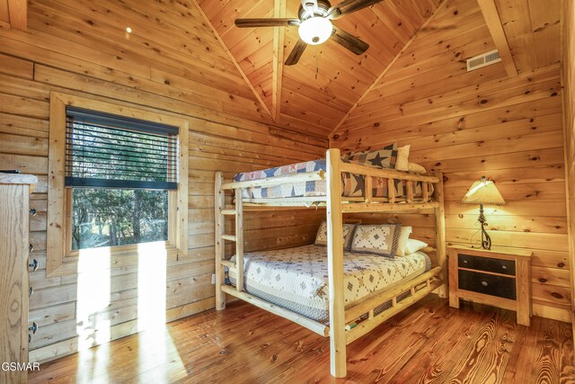 bedroom featuring ceiling fan, wooden ceiling, high vaulted ceiling, wooden walls, and hardwood / wood-style flooring