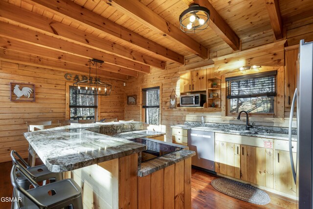 kitchen with beamed ceiling, appliances with stainless steel finishes, dark hardwood / wood-style flooring, and wooden walls