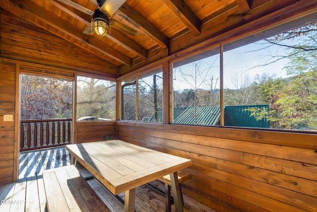 unfurnished sunroom with lofted ceiling with beams, ceiling fan, and wood ceiling