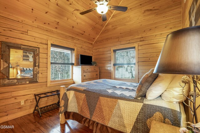 bedroom with ceiling fan, wooden walls, lofted ceiling, and hardwood / wood-style flooring