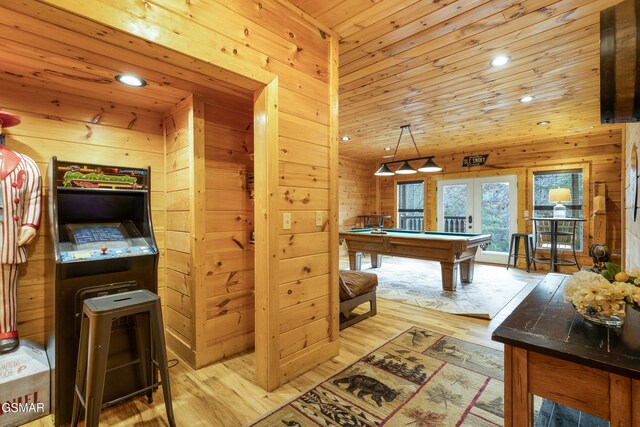 playroom featuring french doors, light hardwood / wood-style flooring, wooden walls, wood ceiling, and pool table