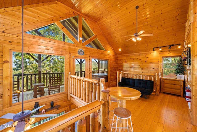 interior space featuring wood walls, high vaulted ceiling, ceiling fan, light hardwood / wood-style floors, and wood ceiling