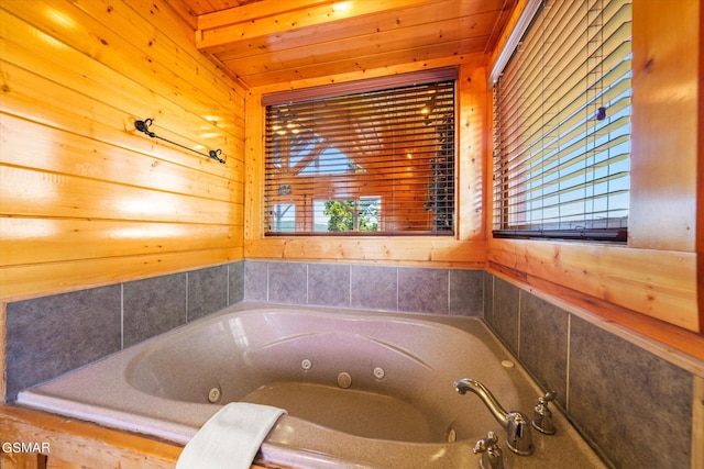 bathroom featuring tiled bath, a wealth of natural light, and wooden ceiling