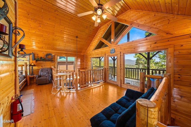 living room featuring ceiling fan, high vaulted ceiling, wooden ceiling, and light wood-type flooring