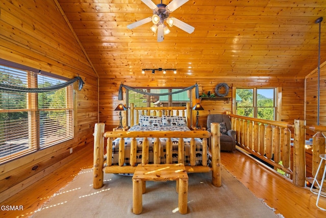 bedroom with wood walls, lofted ceiling, rail lighting, and wooden ceiling