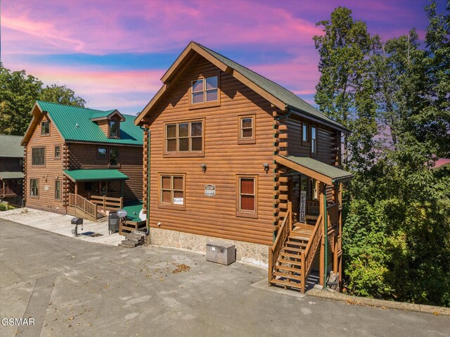 back of house at dusk with log exterior