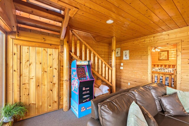 unfurnished living room featuring wooden walls, wooden ceiling, stairs, and carpet floors